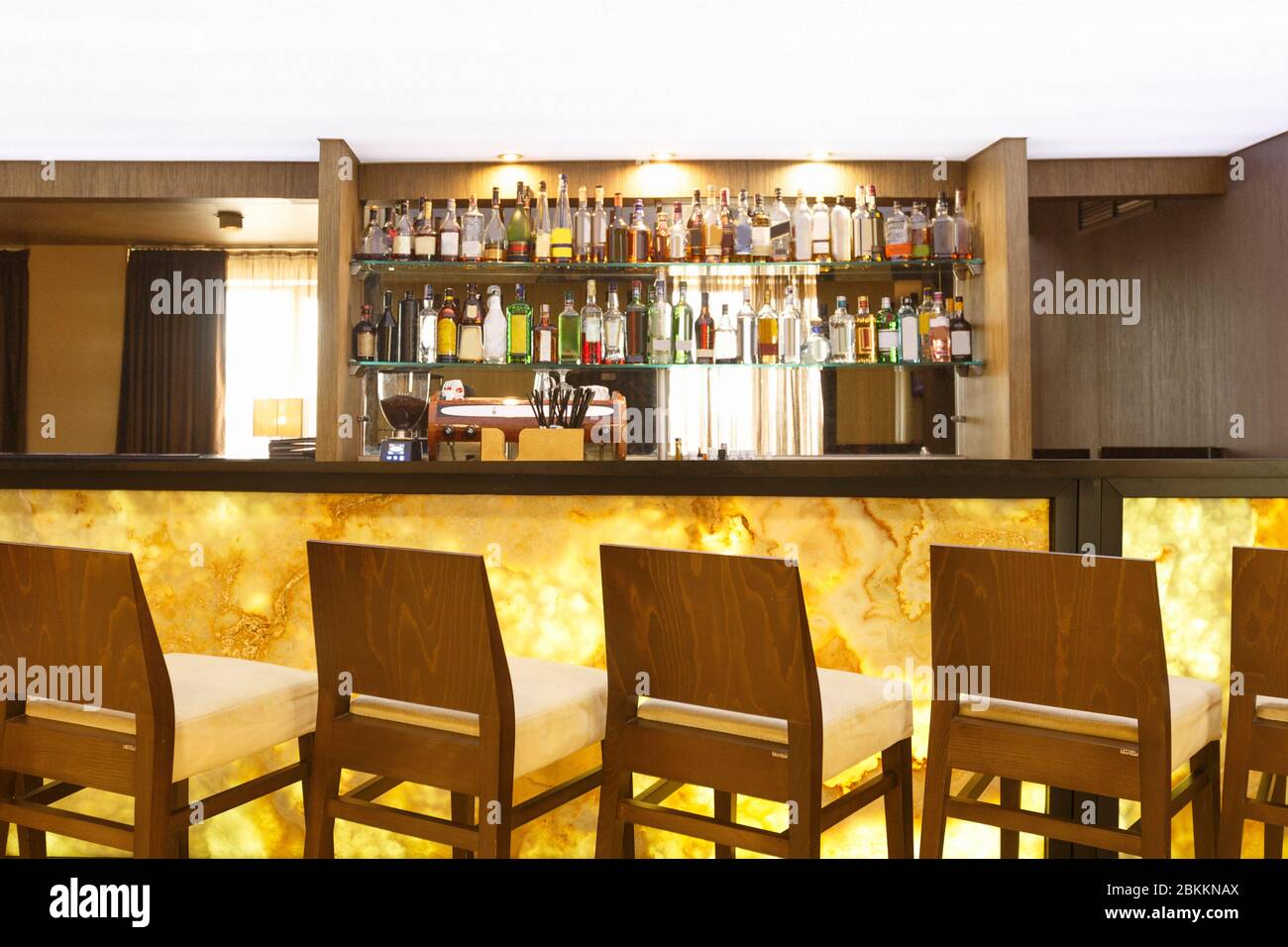 Futuristico bancone bar in marmo giallo con sedie Foto Stock