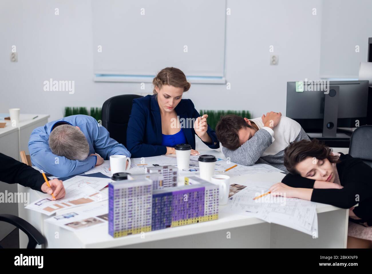 Lavoratori d'ufficio esauriti che riposano sul loro posto di lavoro, mentre hanno una pausa di 5 minuti. Un concetto di uomo d'affari esausto, annoiato, addormentato, stanco. Foto Stock