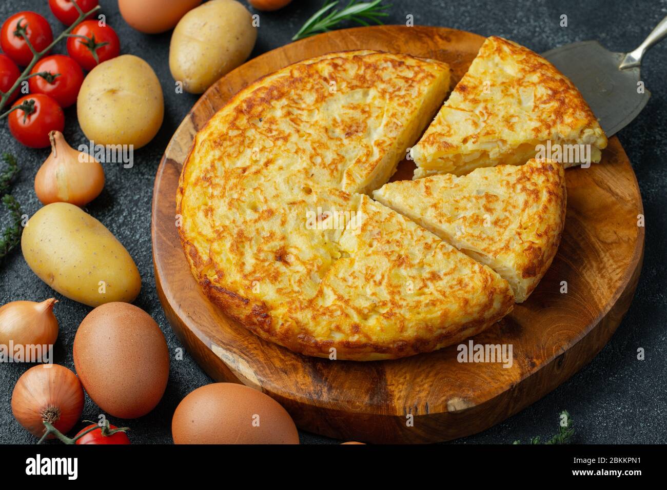 Frittata spagnola con patate e cipolla, cucina tipica spagnola. Tortilla espanola. Rustico sfondo scuro. Vista dall'alto Foto Stock