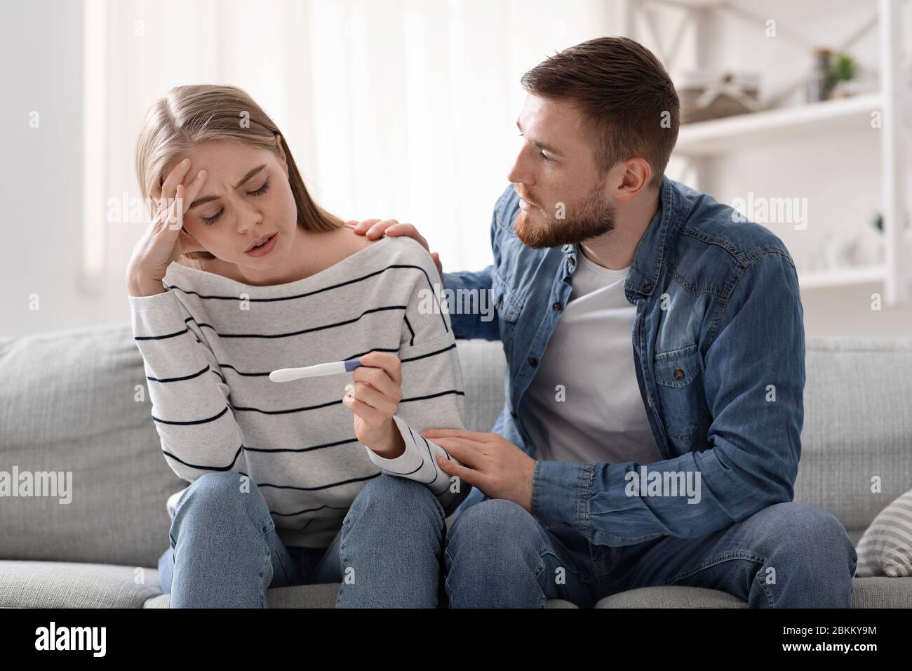 Sconvolto uomo e donna che guarda test di gravidanza negativo Foto Stock