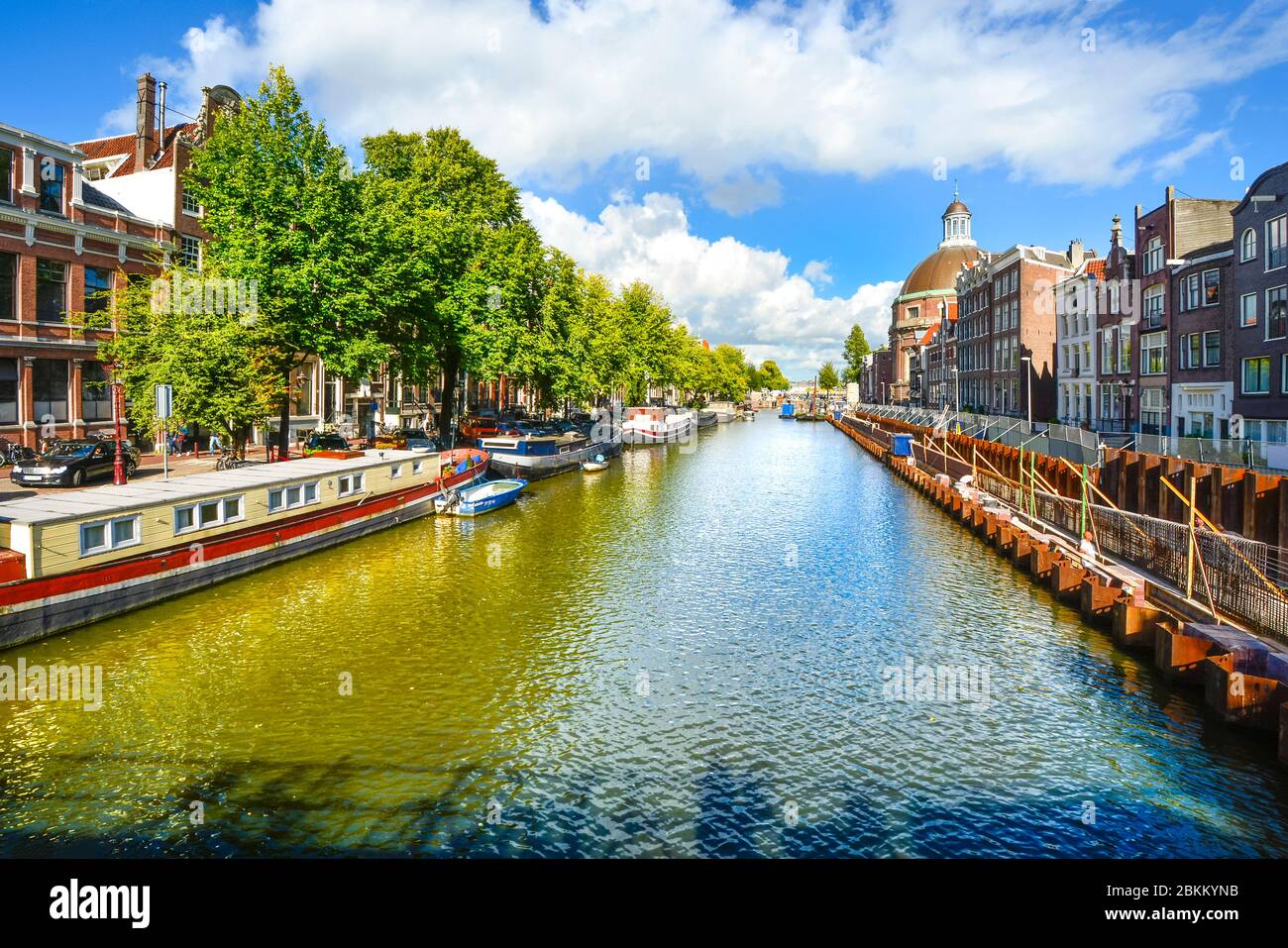 Le barche della casa sono ormeggiate lungo uno dei molti canali di Amsterdam in una giornata di sole all'inizio dell'autunno Foto Stock