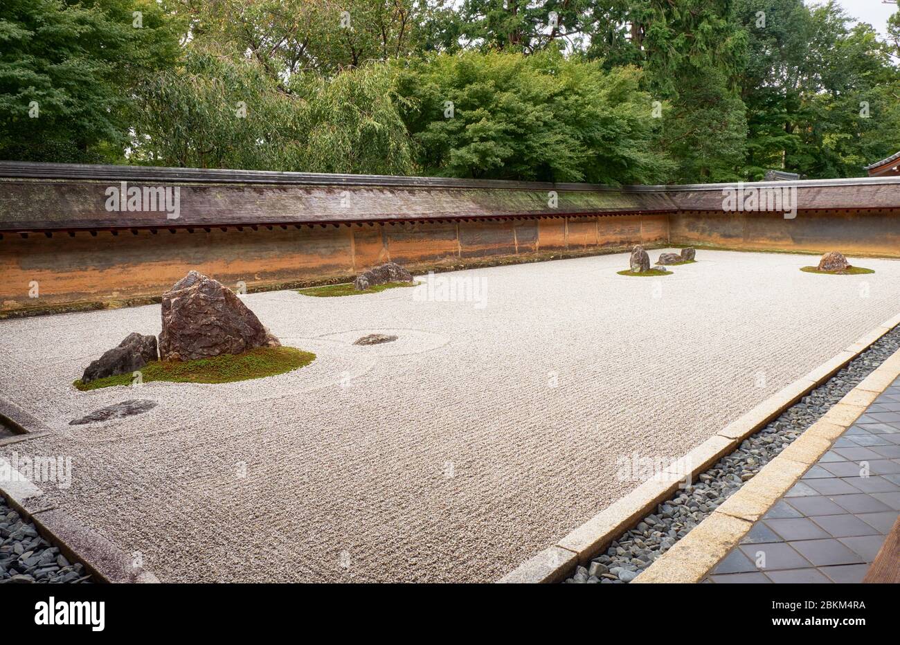 La vista del famoso giardino Zen del tempio Ryoan-ji - il paesaggio secco (karesansui) giardino di roccia, composto da 15 pietre circondate da onde di ghiaia bianca Foto Stock