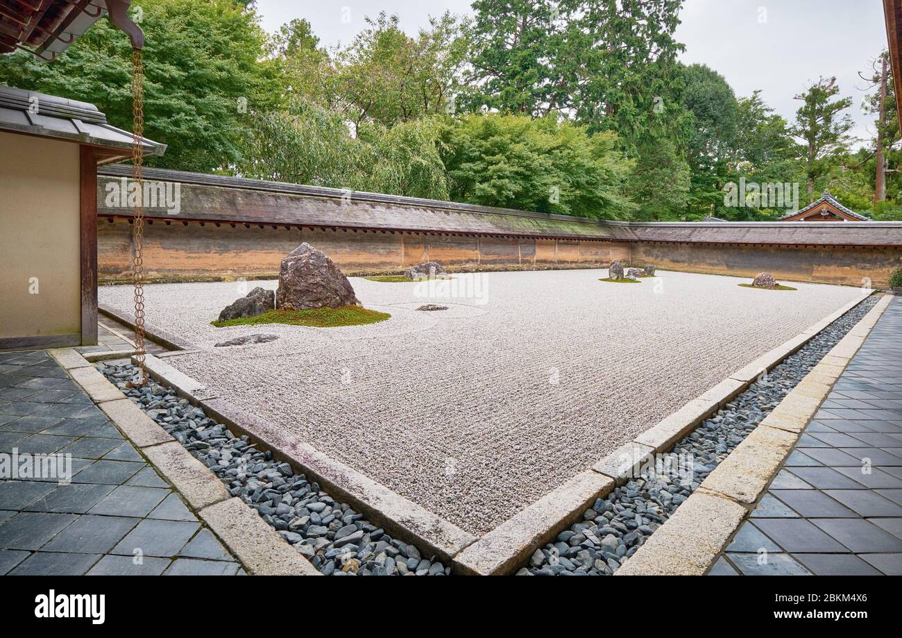 La vista del famoso giardino Zen del tempio Ryoan-ji - il paesaggio secco (karesansui) giardino di roccia, composto da 15 pietre circondate da onde di ghiaia bianca Foto Stock