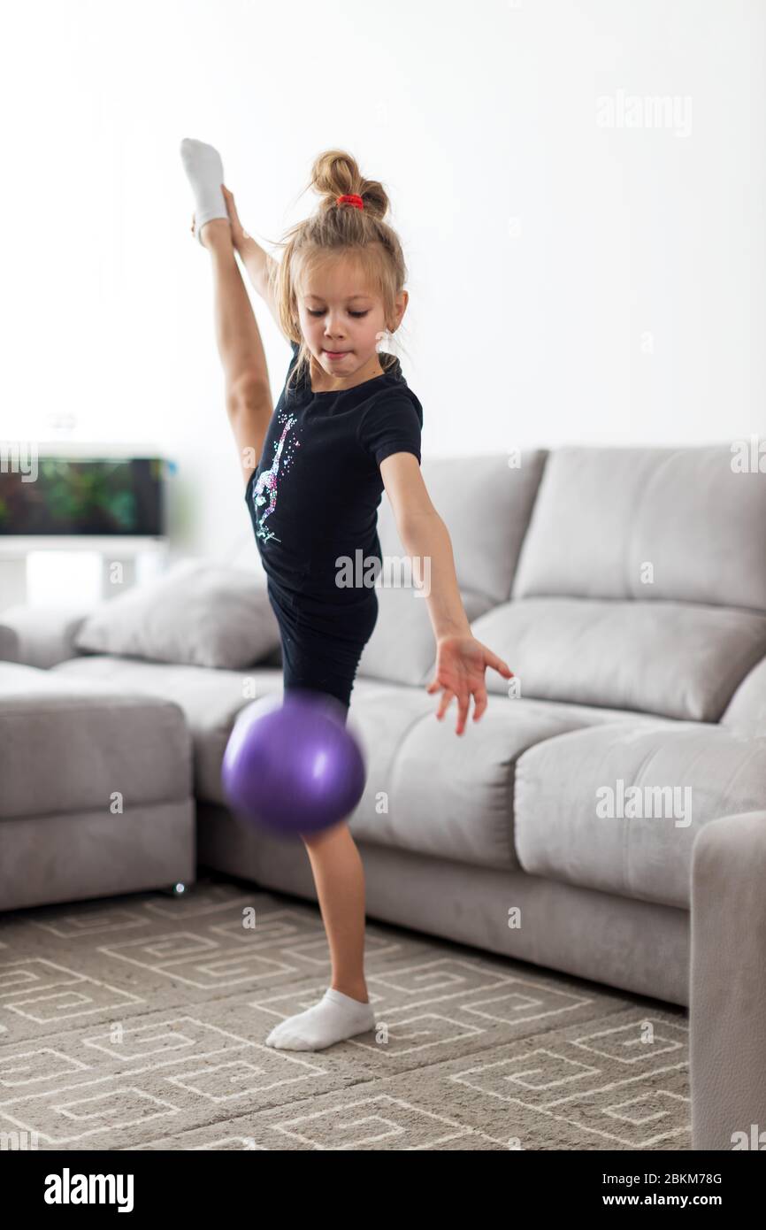 Ginnastica della bambina, esegue varie esercitazioni di ginnastica e di idoneità. Il concetto di infanzia e sport, uno stile di vita sano Foto Stock