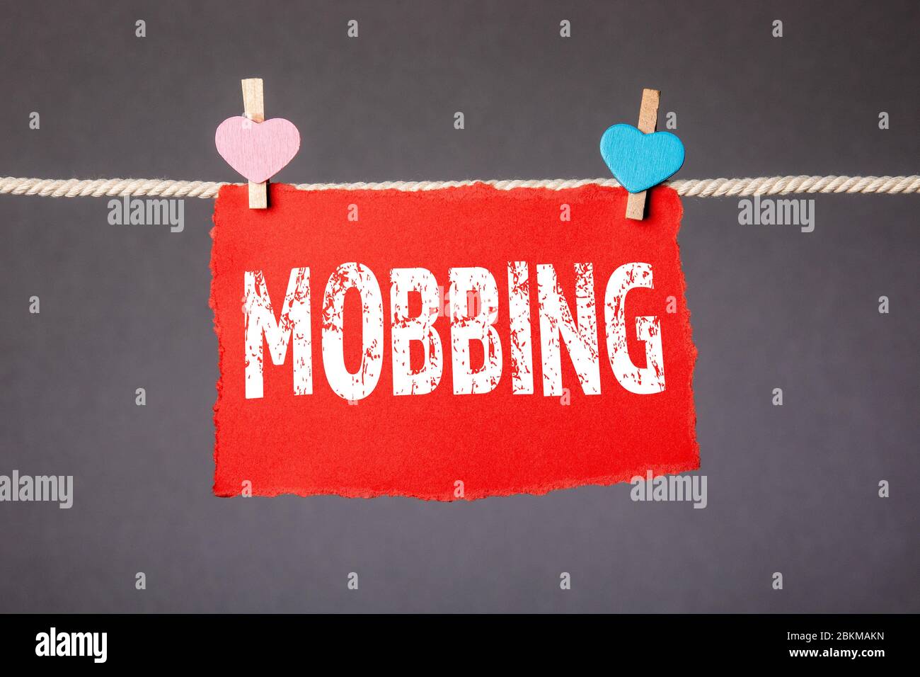 MOBBING. Relazioni, disaccordi, controversie e concetto di violenza. Foglio attaccato con spina sulla corda Foto Stock