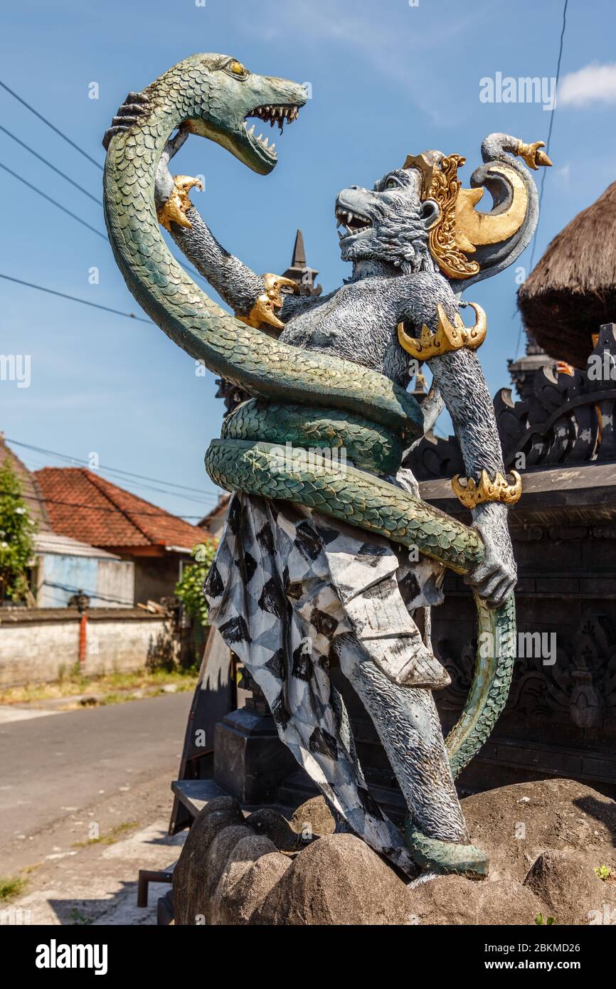Statua di Hanuman, dio indù e divina scimmia (vanara) compagno del dio Rama, combattendo naga (serpente). Bali, Indonesia. Immagine verticale. Foto Stock