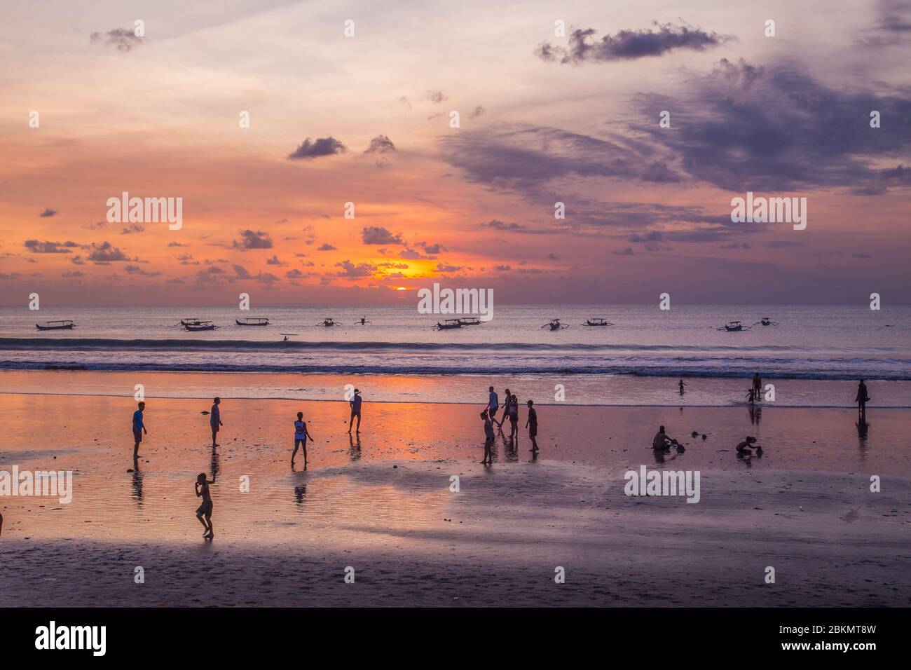 BALI, INDONESIA - 13 APRILE 2017: Persone sulla spiaggia di Kuta a Bali al tramonto. Foto Stock
