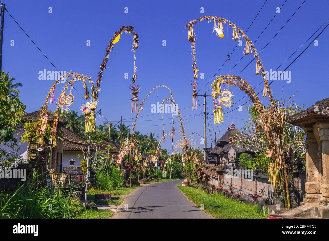 Strade a Bali. I polacchi di Penjor possono essere visti come parte della celebrazione annuale della Galungan. La gente può essere vista. Foto Stock