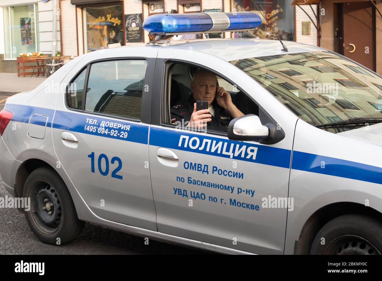 Mosca, Russia - 23 aprile 2020, l'ufficiale di polizia in un'automobile pattuglia le strade durante la quarantena a Mosca Foto Stock