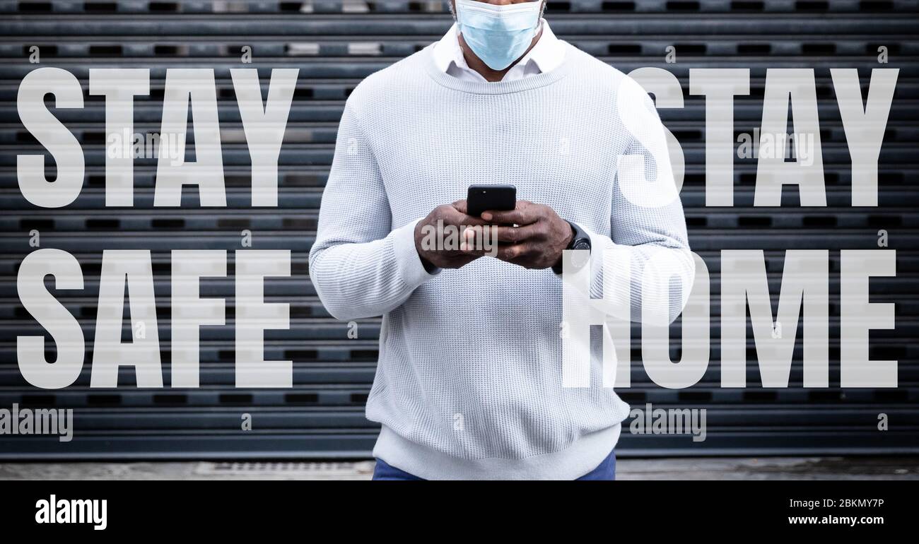 Razza mista uomo in strada con parole rimanere a casa Rimani sicuro durante la pandemia di coronavirus 19 Foto Stock