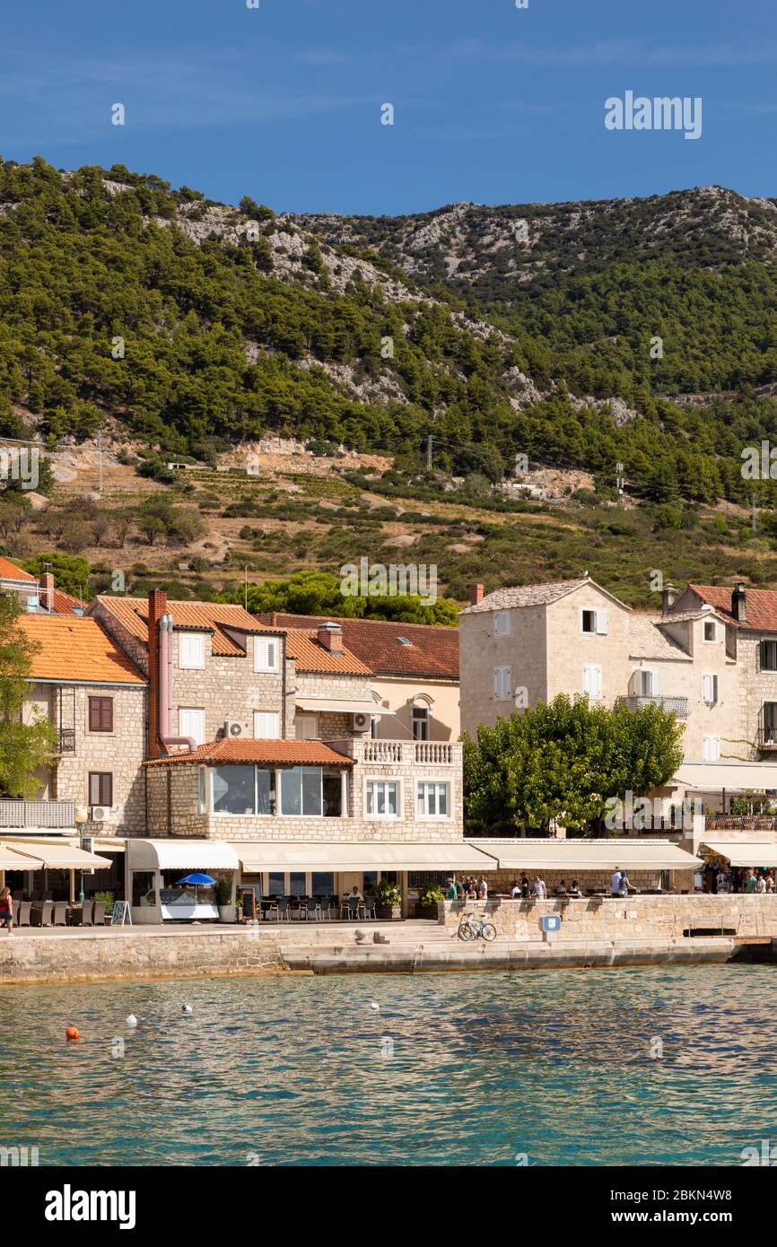 Bol, Croazia, 10 settembre 2019. Un viale e il porto di Bol sull'isola di Brac in Dalmazia in una giornata di sole in estate. Una barca e turisti a piedi Foto Stock
