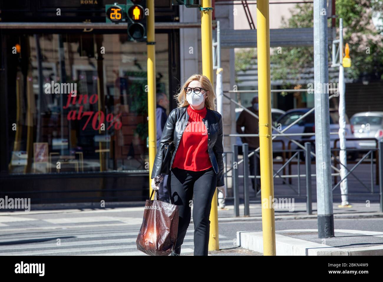 Pedoni con i volti maschera passeggiata nel centro di Roma, Italia, Lunedi, 4 maggio 2020. Foto Stock