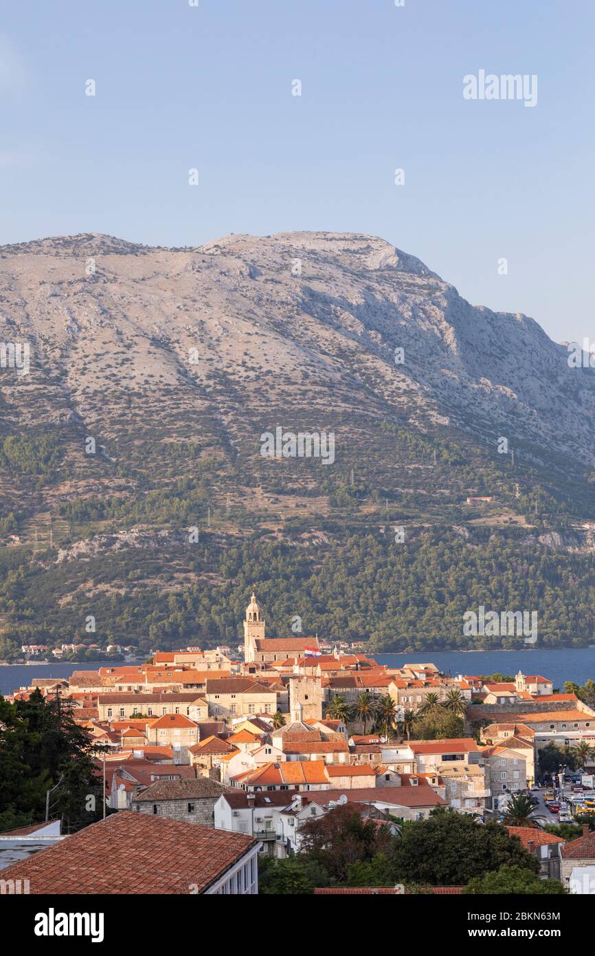 Isola di Korcula con la cattedrale, la città e le case in una giornata di sole durante il tramonto in estate. Bella architettura veneziana, alberi e montagna Foto Stock
