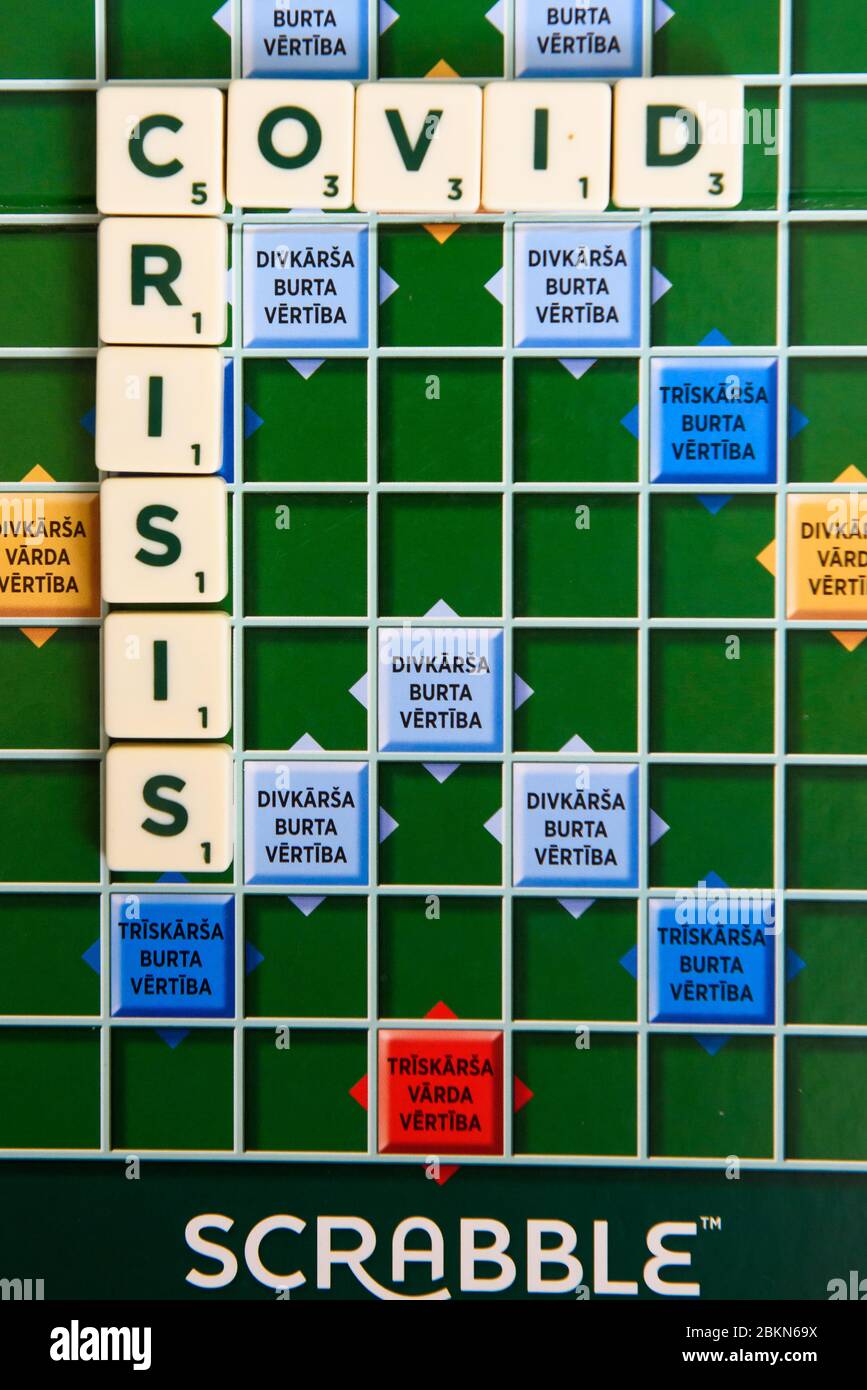 RIGA, LETTONIA. 3 maggio 2020. Nome COVID sul gioco da tavolo Scrabble. Scrabble è un gioco di parole in cui due a quattro giocatori segnano punti posizionando le tessere, eac Foto Stock