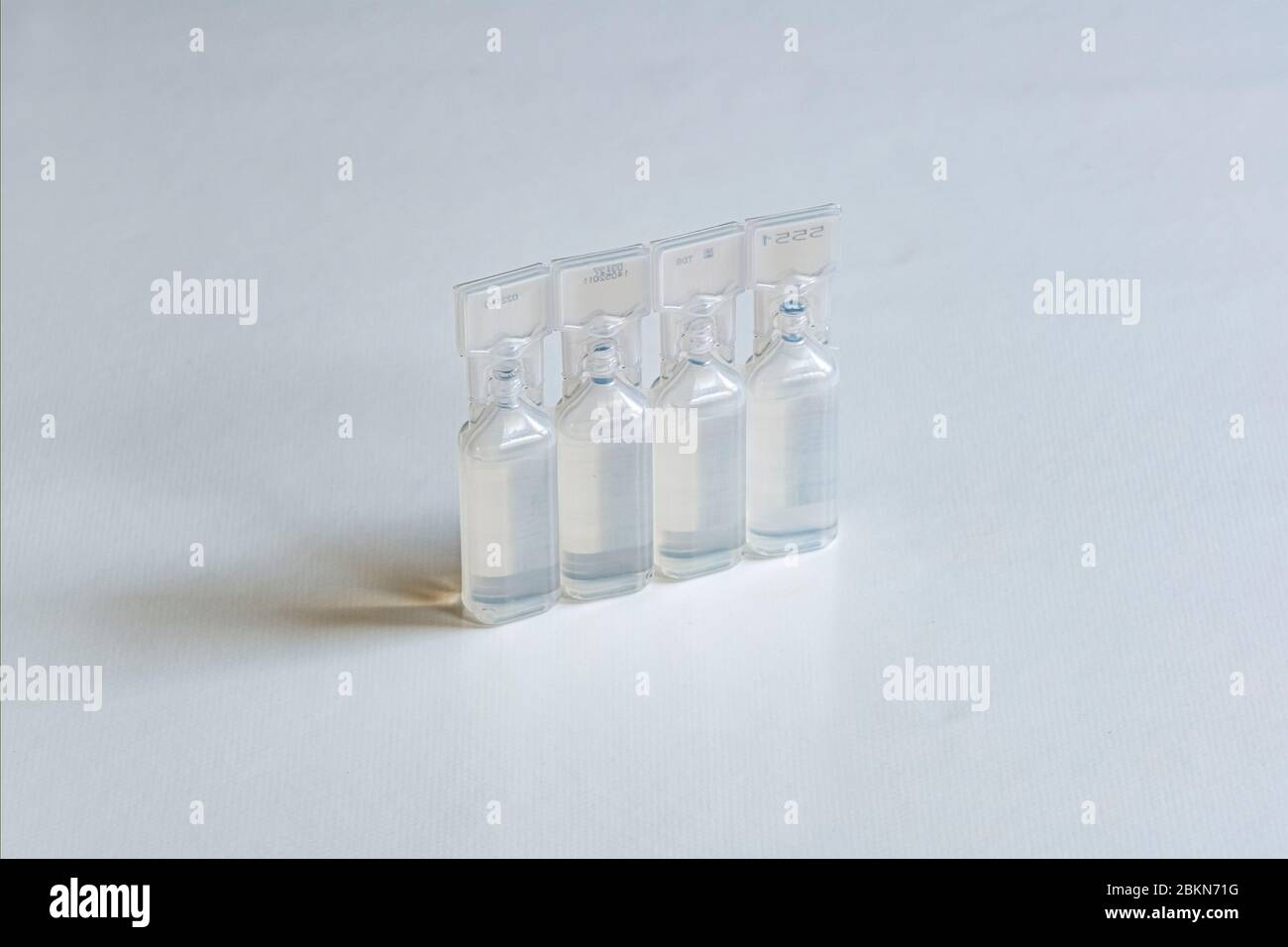 Una confezione di quattro piccoli contenitori, riempita con soluzione di clucosio per iniezione, riportata su una tabella bianca Foto Stock