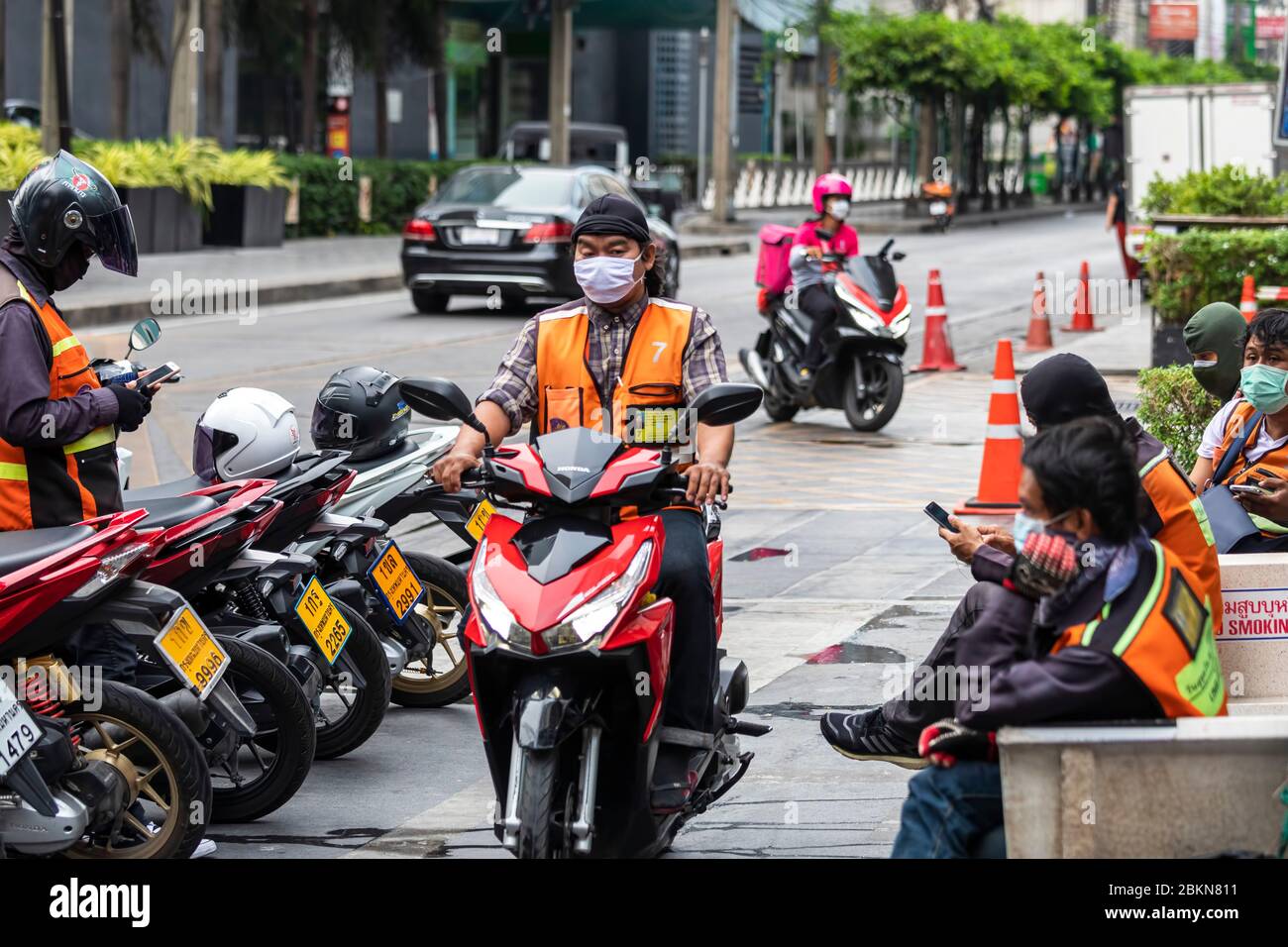 I tassisti di moto indossano maschera facciale in attesa dei clienti durante la pandemia Covid 19, Bangkok, Thailandia Foto Stock