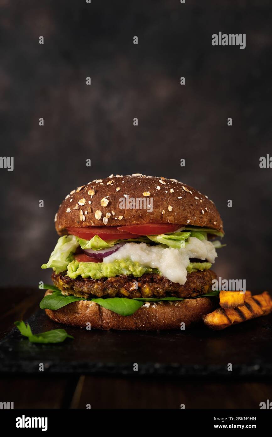 Delizioso hamburger di lenticchie vegane fatto in casa su uno sfondo rustico scuro Foto Stock