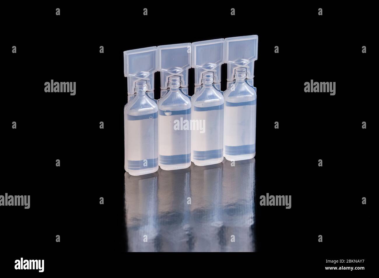 Una confezione di quattro piccoli contenitori, riempiti con soluzione di clucosio per iniezione, da esporre su un tavolo nero Foto Stock