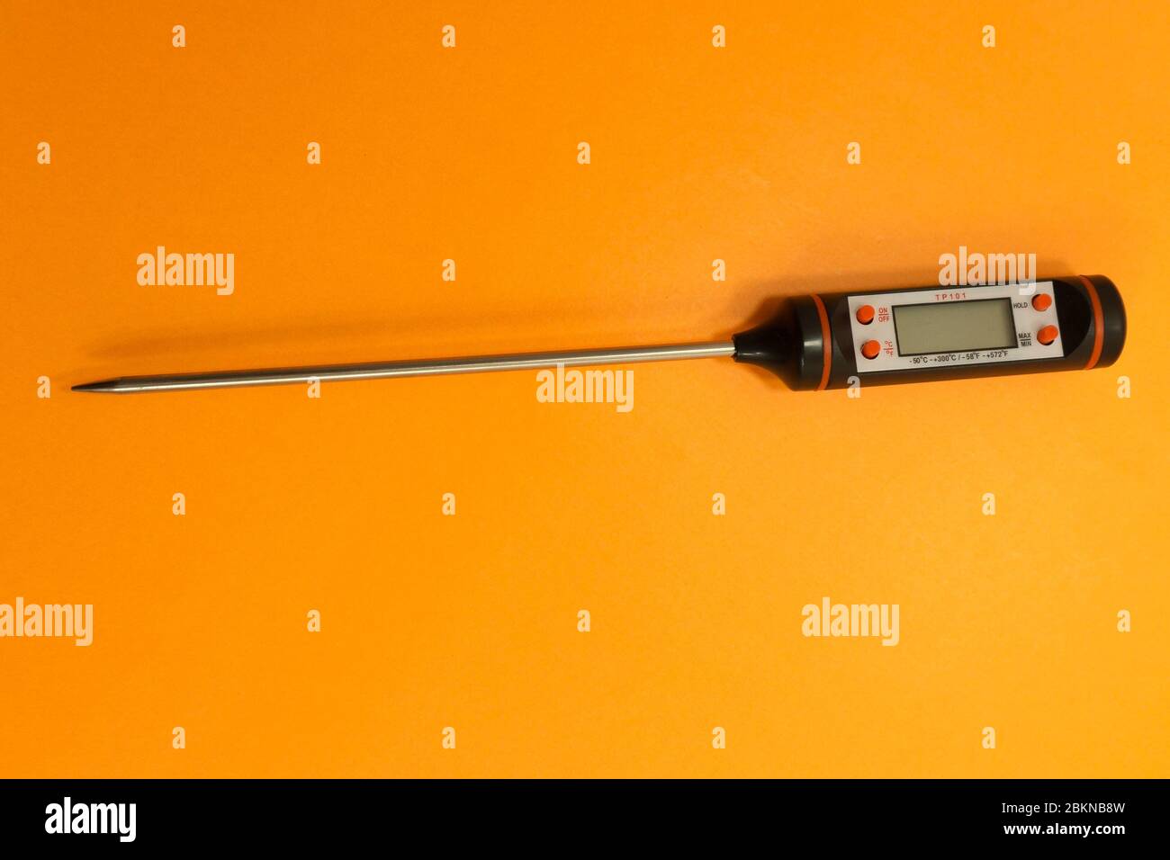 Termometro elettronico per carne su fondo arancione . Foto Stock