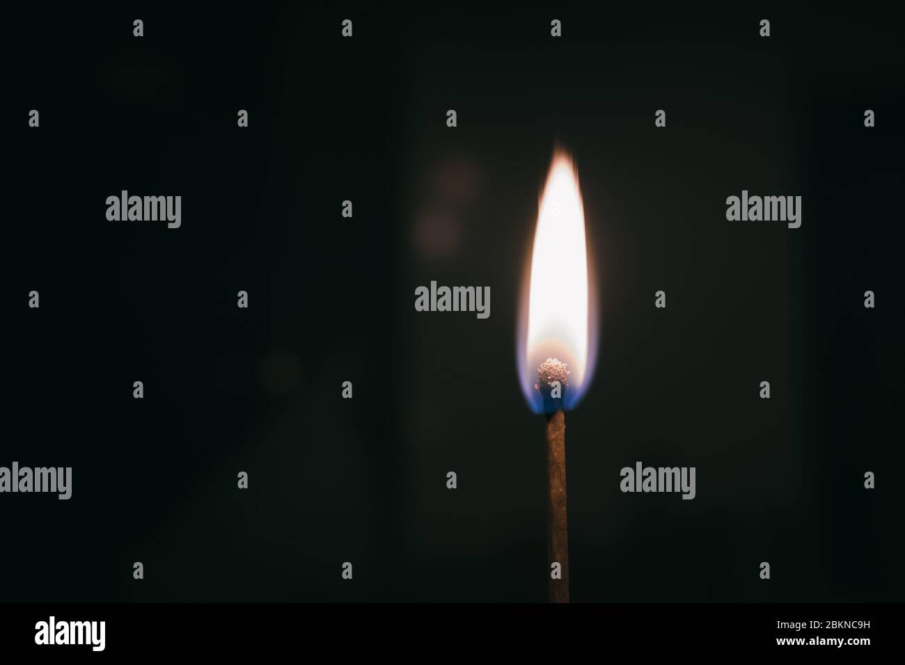 Fiamma bruciante su un bastone fiammifero isolato su uno sfondo nero Foto Stock