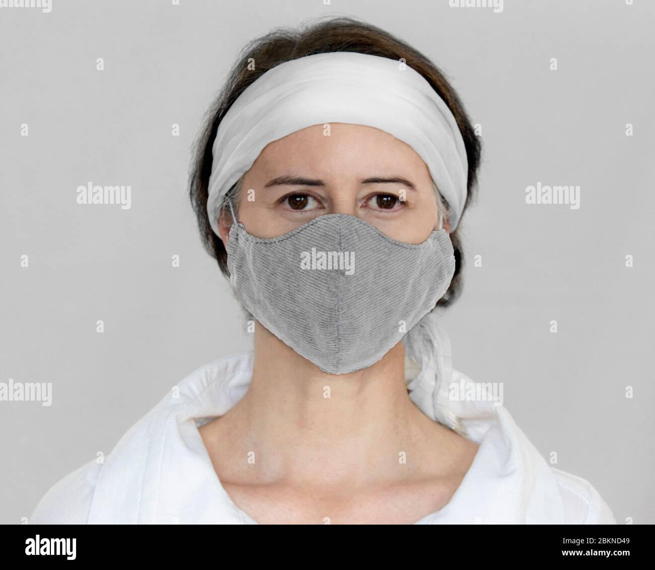 Una donna con una maschera facciale in tessuto Foto Stock