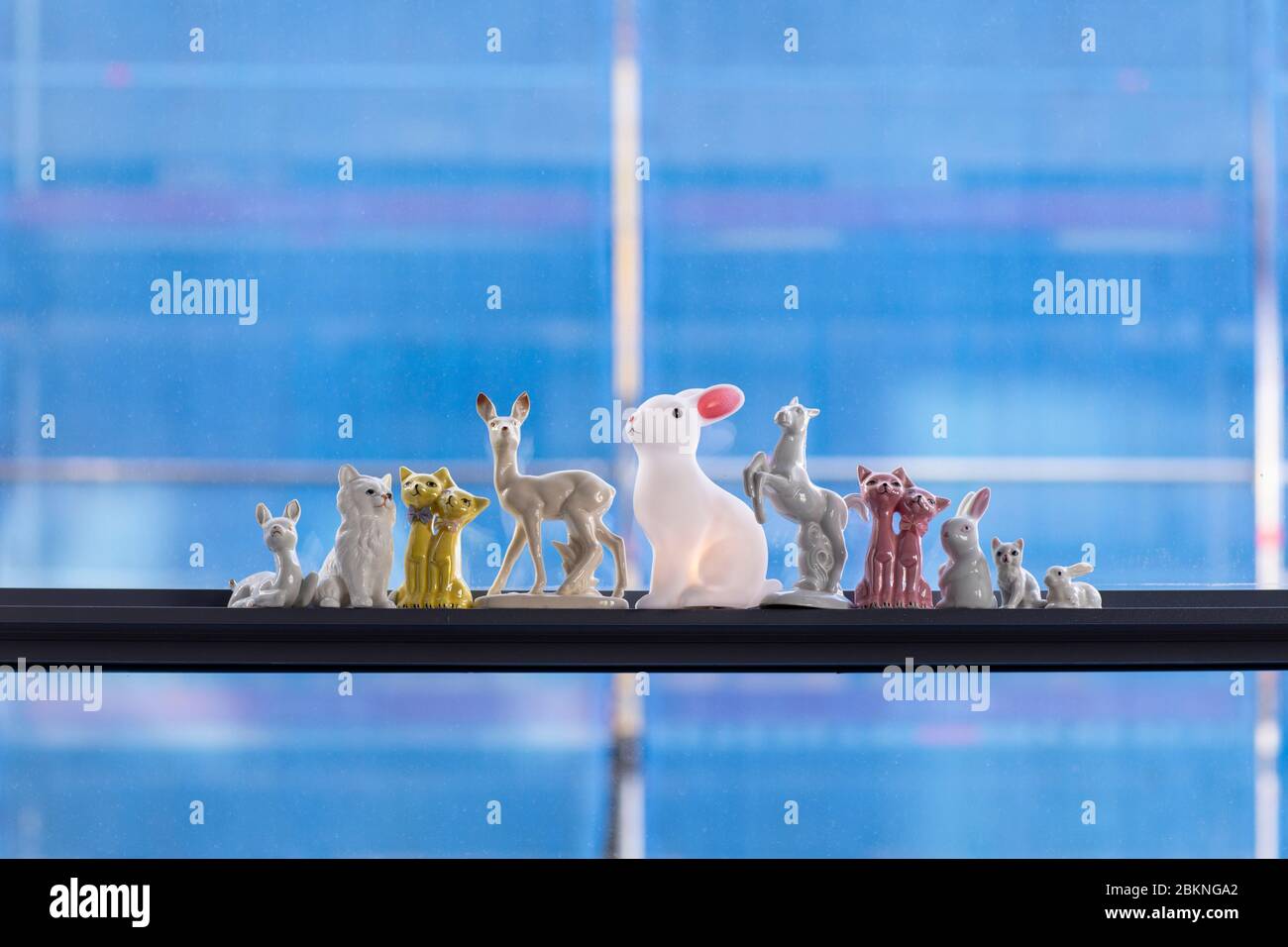 Un dettaglio di una collezione di oggetti animali colorati in un interno loft città. Un moderno, mix e abbinare eclettico stile casa con conigli bianchi, cavalli, Foto Stock