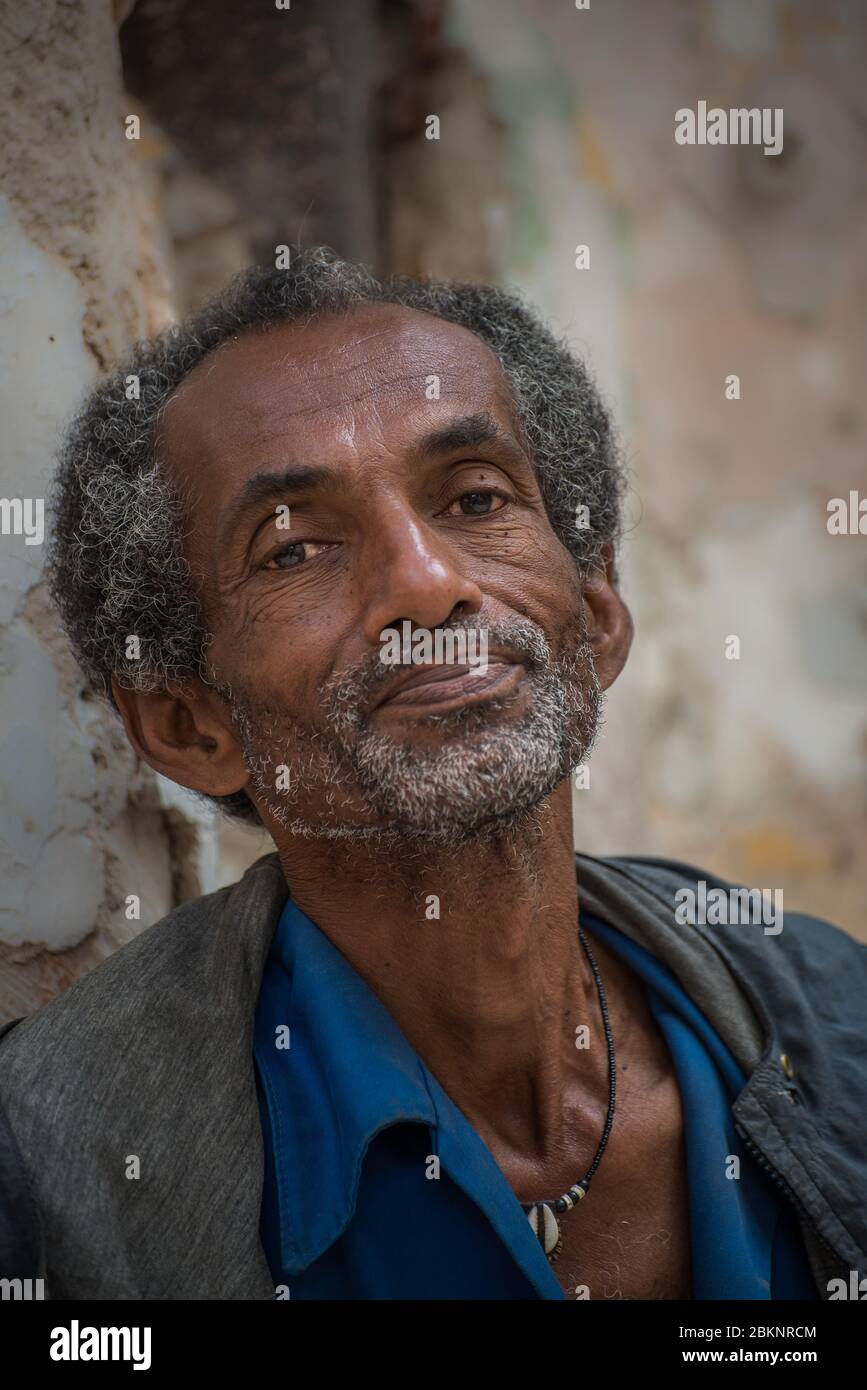 Ritratto di un uomo cubano appoggiato al muro di un vecchio edificio, la Habana Vieja, l'Avana Vecchia, Cuba Foto Stock
