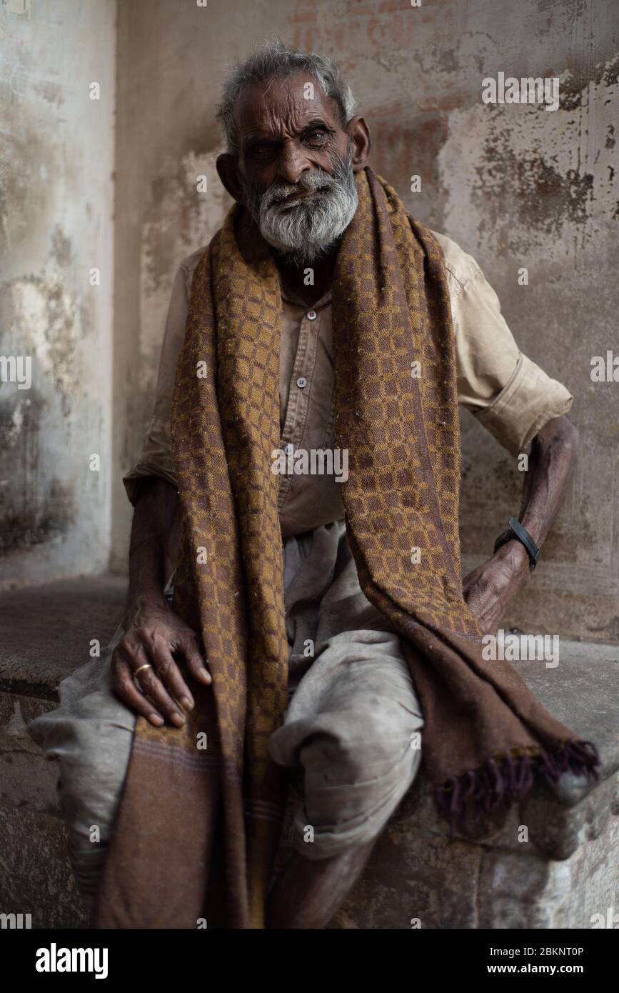 Mendicante indiano. Vecchio uomo con bearded seduto con sciarpa marrone. Jaipur, Rajasthan, India Foto Stock