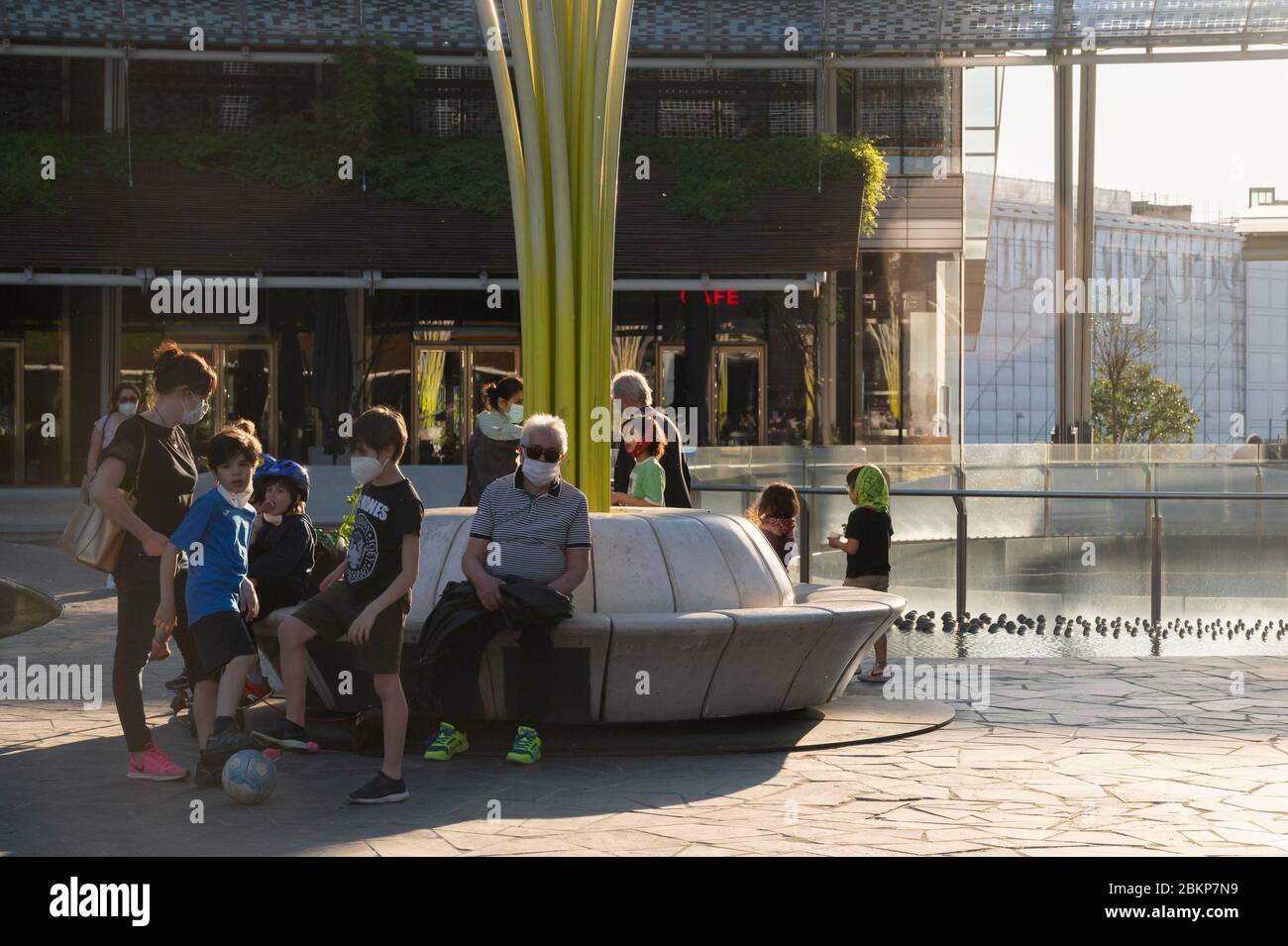 Bambini in Piazza Gae Aulenti indossando maschere facciali come misura preventiva contro COVID-19. Il 4 maggio l'Italia è entrata nella sua seconda fase del piano di emergenza Covid-19. Secondo il nuovo decreto nazionale, è iniziata una lenta revoca delle restrizioni. A Milano diverse categorie di lavoro hanno potuto tornare a lavorare con misure precauzionali e i cittadini hanno potuto praticare attività sportive e portare bambini in parchi aperti rispettando le regole della distanza sociale. Foto Stock