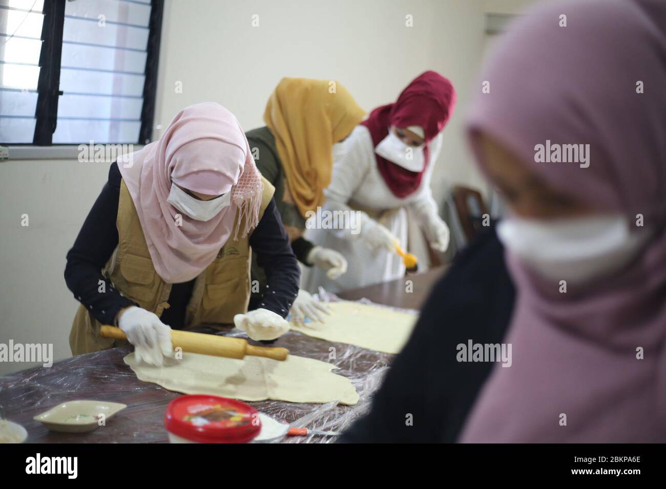 La striscia di Gaza, la striscia di Gaza, la Palestina. 5 maggio 2020. Donne palestinesi lavorano in un centro della striscia di Gaza per cuocere torte, pizza e timo e distribuirli sulle strade nel mese sacro del Ramadan. Credit: Mahmoud Khattab/Quds Net News/ZUMA Wire/Alamy Live News Foto Stock