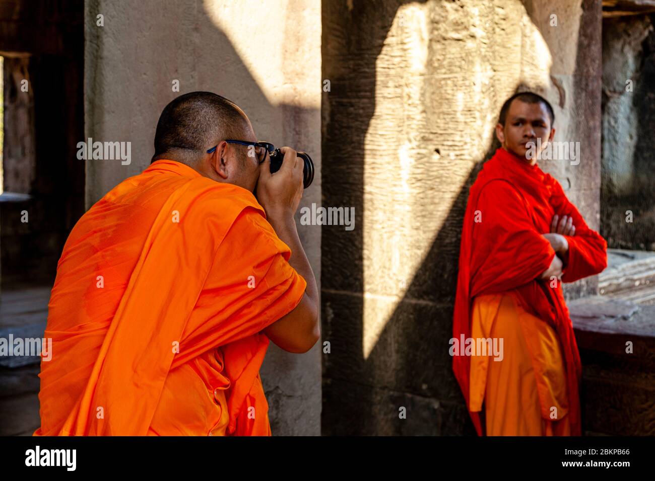 Un monaco buddista che prende le foto, Angkor Wat, Siem Reap, Siem Reap Province, Cambogia. Foto Stock