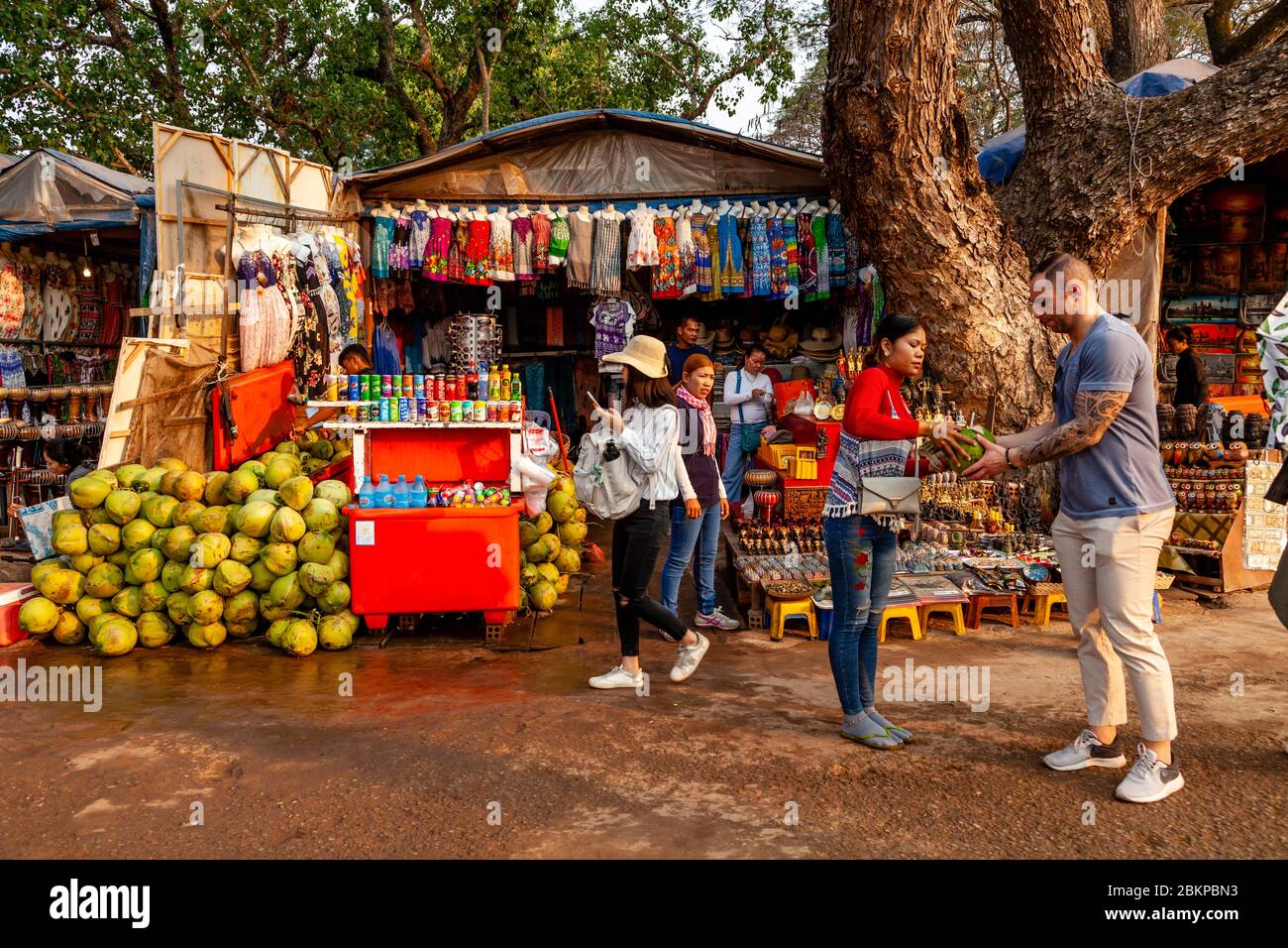 Un visitatore acquista UNA bevanda fresca al cocco da UN calice nel complesso del Tempio di Angkor Wat, Siem Reap, provincia di Siem Reap, Cambogia. Foto Stock
