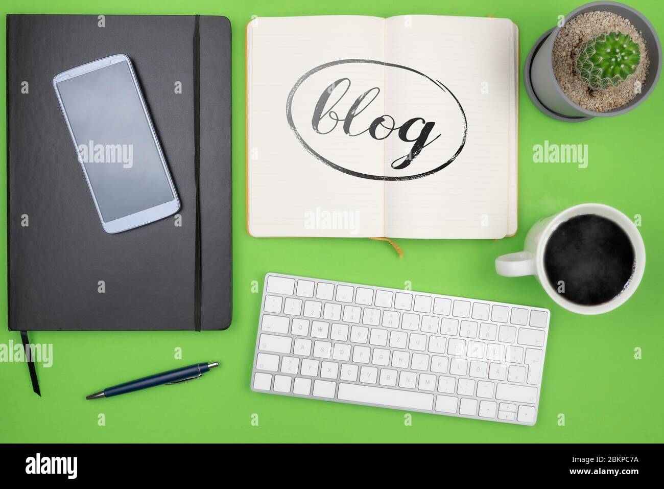 Blogging concetto, vista superiore di parola BLOG su nota pad sulla scrivania con tastiera del computer, tazza caffè e pianta in vaso Foto Stock