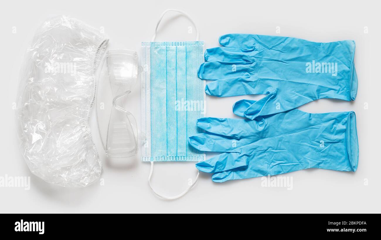 Cappello, occhiali, guanti e maschera monouso. Mezzi di protezione individuale Foto Stock