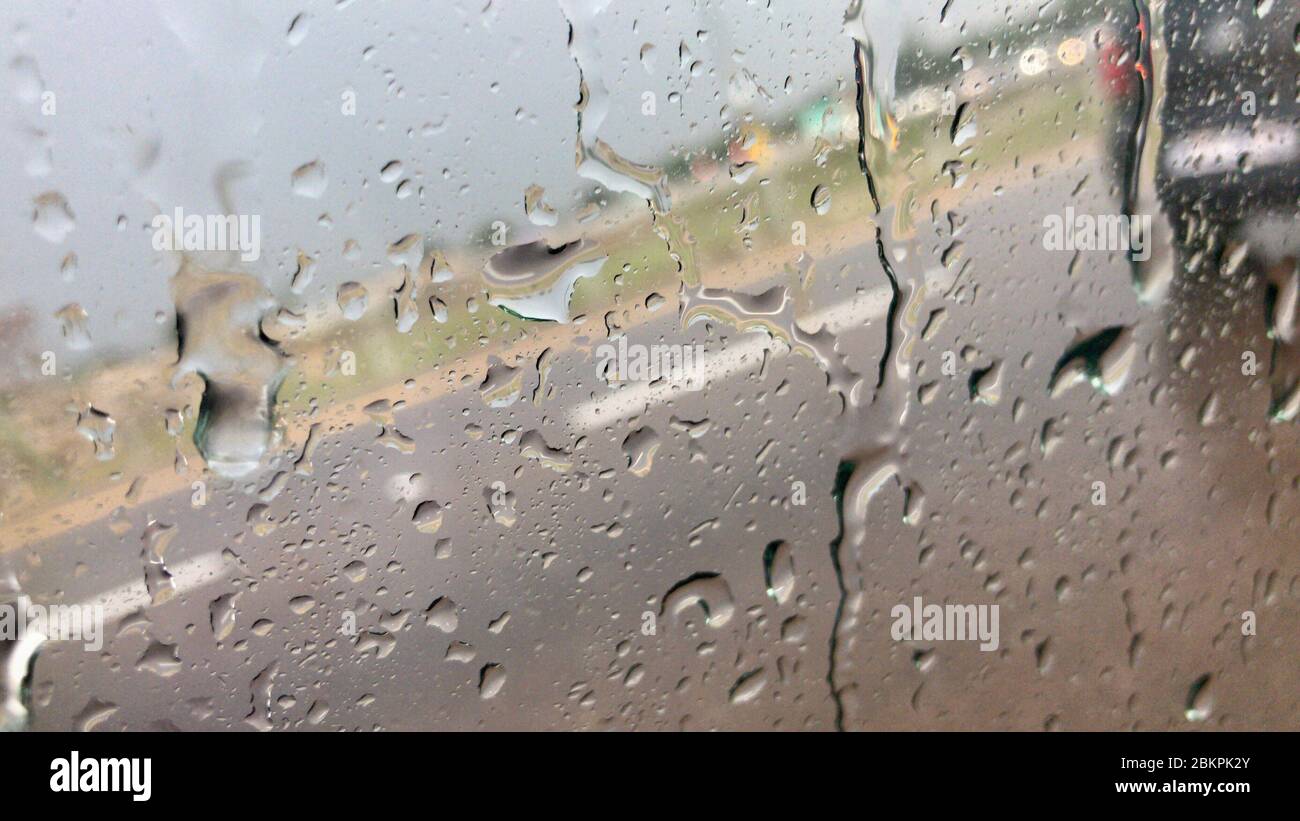 Pioggia che spruzza sul finestrino dell'auto durante la pioggia intensa Foto Stock
