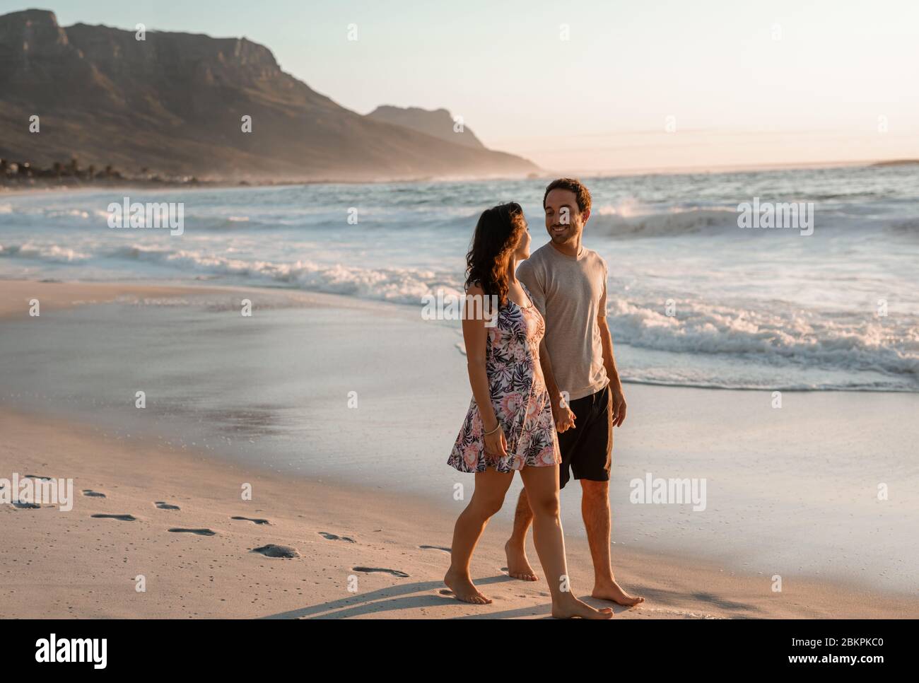 Coppia giovane e amorevole che cammina lungo una spiaggia di sabbia Foto Stock