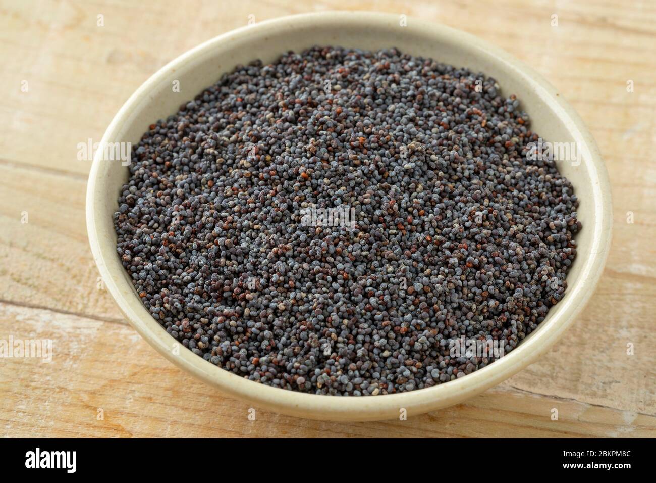 Ciotola con il seme nero del papavero come ingrediente Foto Stock