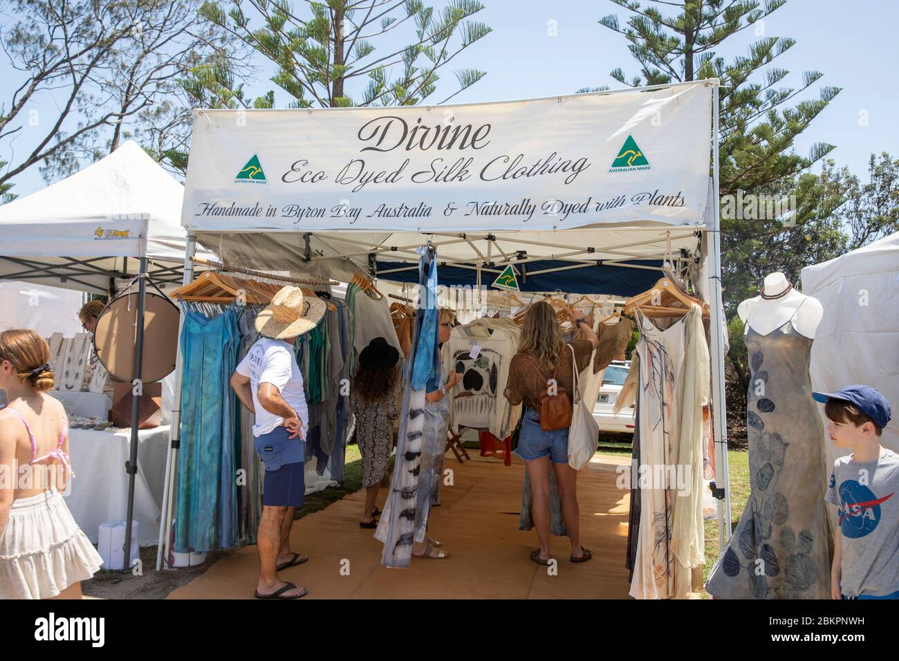 Byron Bay mercato e la gente che naviga lo shopping ad una stalla di abbigliamento di seta tinta nel mercato, nuovo Galles del Sud, Australia Foto Stock