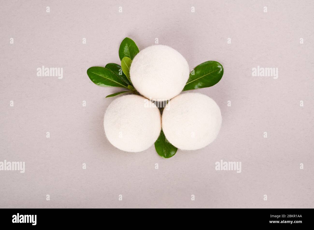 Palle per asciugaboancheria su sfondo grigio. Lavanderia ecocompatibile. Sfere di lana non tossiche riutilizzabili. Asciugatura alternativa della biancheria. Spazio copia. Disposizione piatta. Sopra. Foto Stock