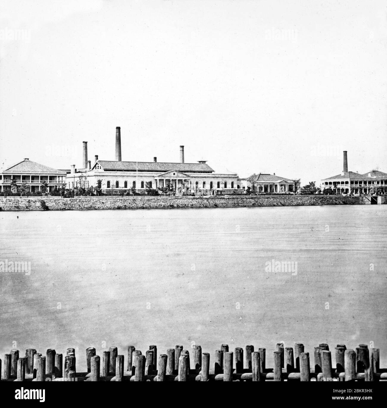 [ 1870 Giappone - TITOLO ] - la zecca imperiale sul fiume Okawa a Osaka. Istituita per modernizzare il sistema monetario giapponese, la cerimonia inaugurale della Mint si è svolta il 4 aprile 1871 (Meiji 4). Fino al 1871, il Giappone non aveva una moneta unica. Ogni dominio ha emesso le proprie valute. Per il commercio internazionale, il dollaro messicano è stato usato spesso. La Zecca ha quindi svolto un ruolo importante nella creazione di una moneta stabile e l'ascesa dell'industria e della cultura moderna in Giappone. vetrino vintage del xix secolo. Foto Stock