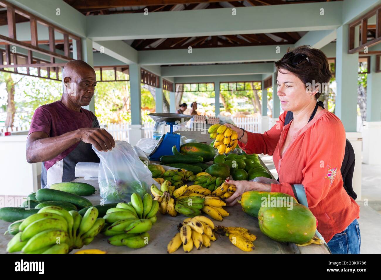 Seychelles, isola di Digue, donna che acquista frutta al mercato fresco Foto Stock