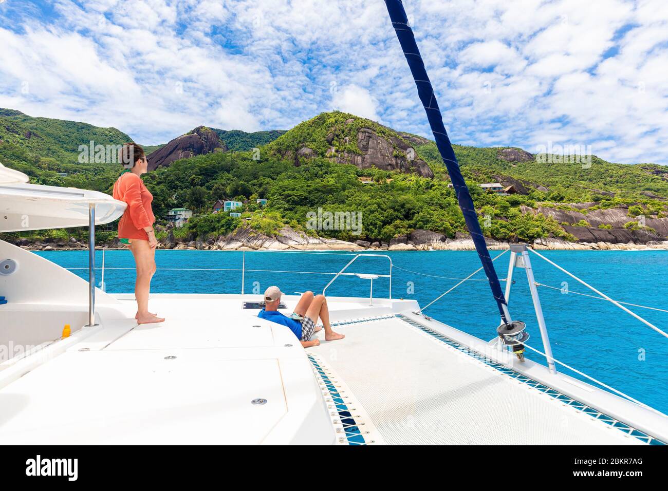 Seychelles, Mah? isola, North Point, uomo e donna che navigano a bordo di un Moorings 4800 di fronte alla costa Foto Stock