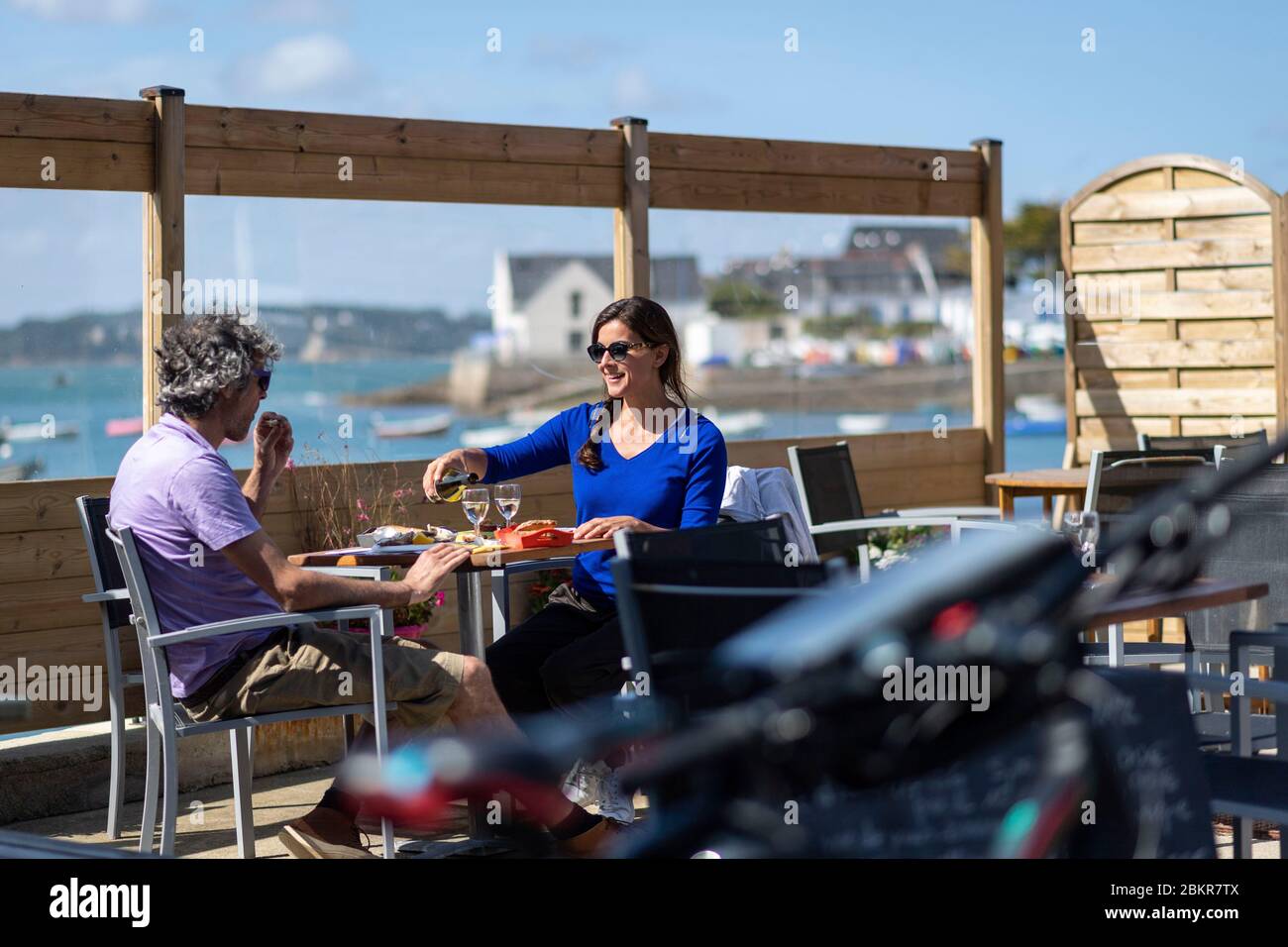 Francia, Finistere, Plougasnou, cicloturisti degustazione ostriche al porto di Terenez, lungo la strada marittima bicicletta Foto Stock