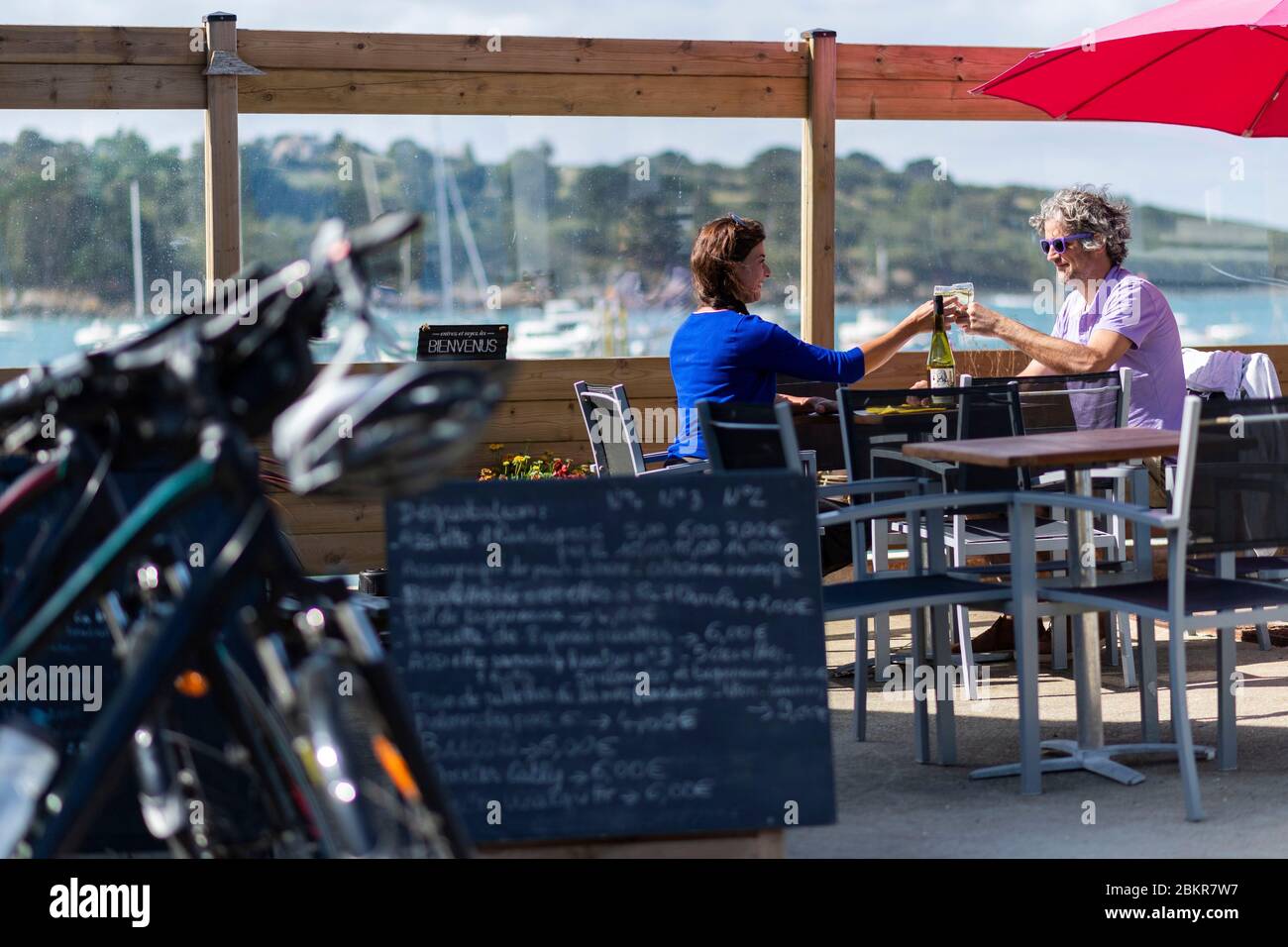 Francia, Finistere, Plougasnou, cicloturisti degustazione ostriche al porto di Terenez, lungo la strada marittima bicicletta Foto Stock
