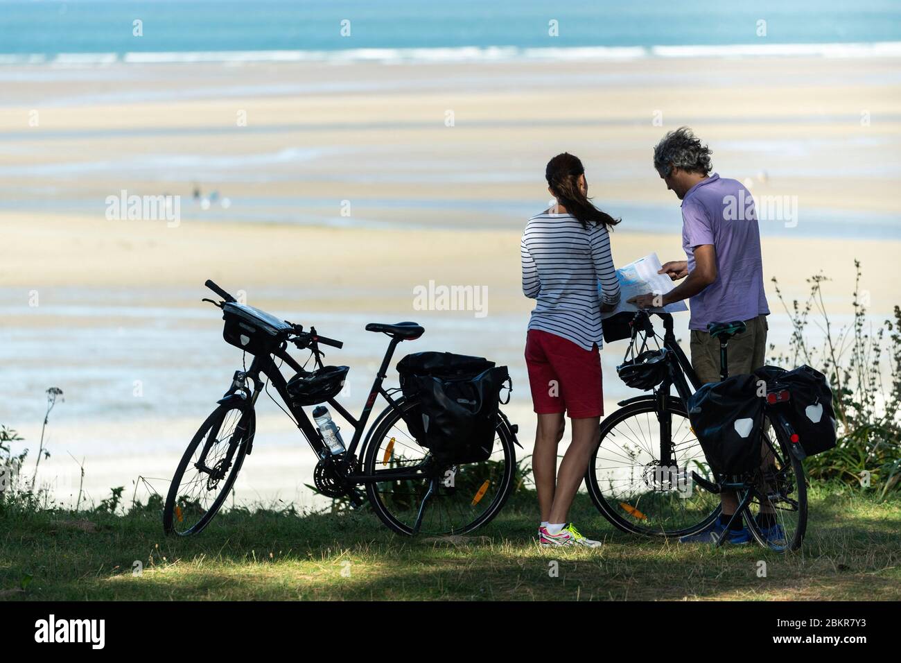 Francia, Finistere, Locquirec, ciclisti di fronte a Port Beach, lungo la strada marittima della bicicletta Foto Stock