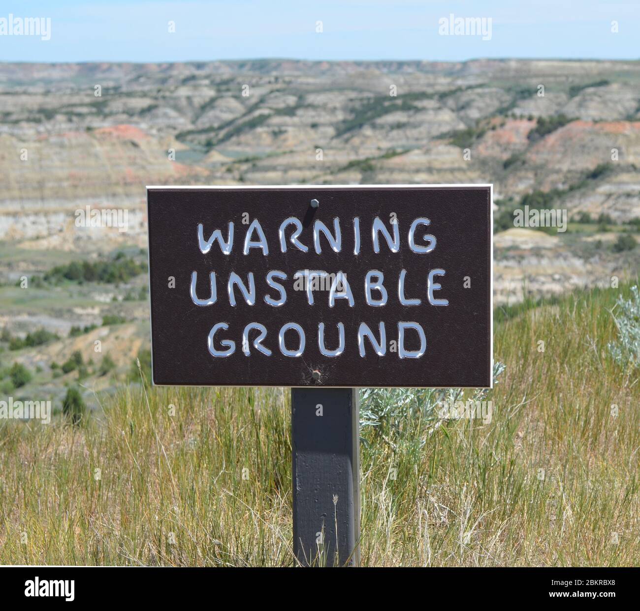 MEDORA, NORTH DAKOTA - 6 GIUGNO 2017: Cartello di avvertimento di suolo instabile vicino al centro visitatori di Painted Canyon lungo la i-94 nel Parco Nazionale di Theodore Roosevelt Foto Stock