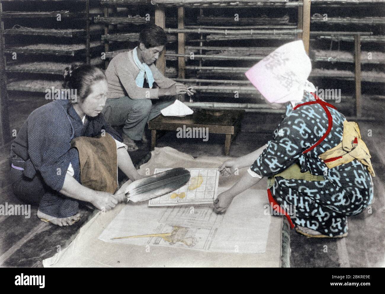 [ 1910s Giappone - Japanese Silk Farming ] – due donne stanno raccogliendo bachi da seta che hanno appena schiantato dalle carte d'uovo. Sul retro un uomo sta pesando. Questa è l'immagine 2 di 17 di 'l'industria della seta del Giappone,' un libro pubblicato da Ueda basato Tokyo. stampa collotipo vintage del xx secolo. Foto Stock