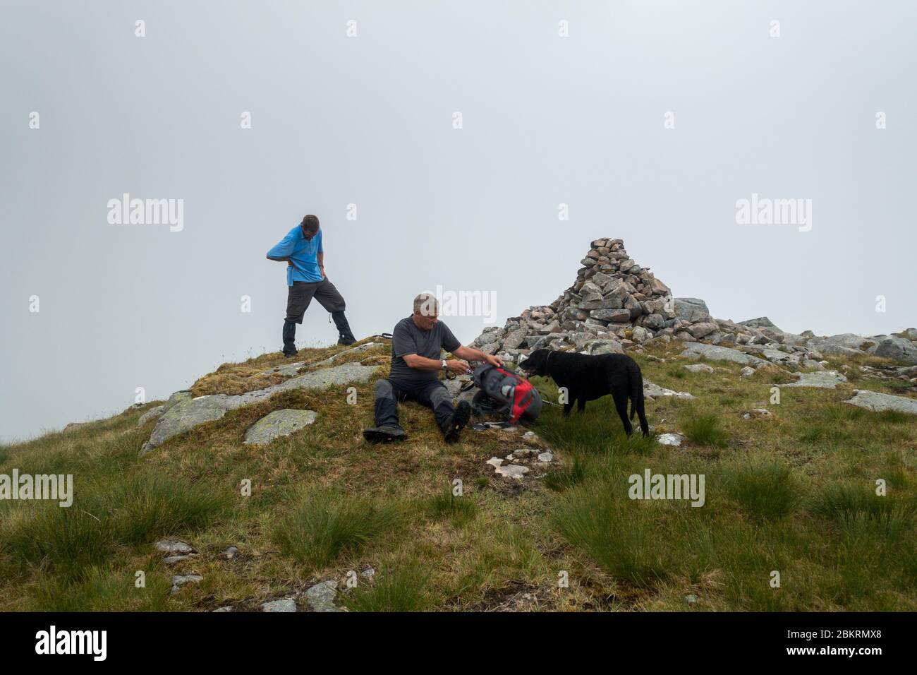 La cima cairn di Beinn na Cille a Morvern nelle Highlands scozzesi. 2 uomini e un rifante riccio rivestito Foto Stock