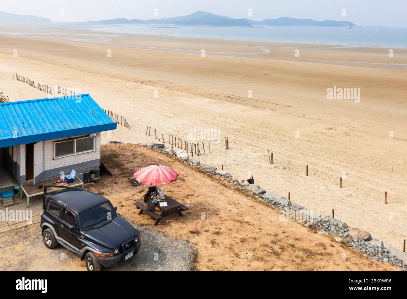 Corea del Sud, Provincia di Chungcheong del Sud, dune di sabbia Sinduri, turista che soggiornano in un bungalow sul tetto blu sulla spiaggia e 4x4 Korando Ssangyong jeep Foto Stock