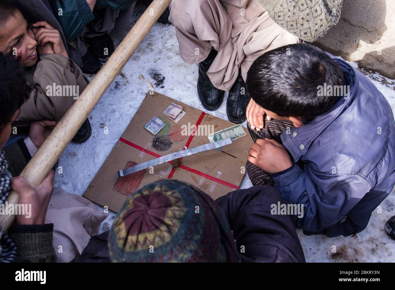 Kabul, Afghanistan - Gennaio 2005: I ragazzi giocano in un gioco da tavolo fatto in casa Foto Stock